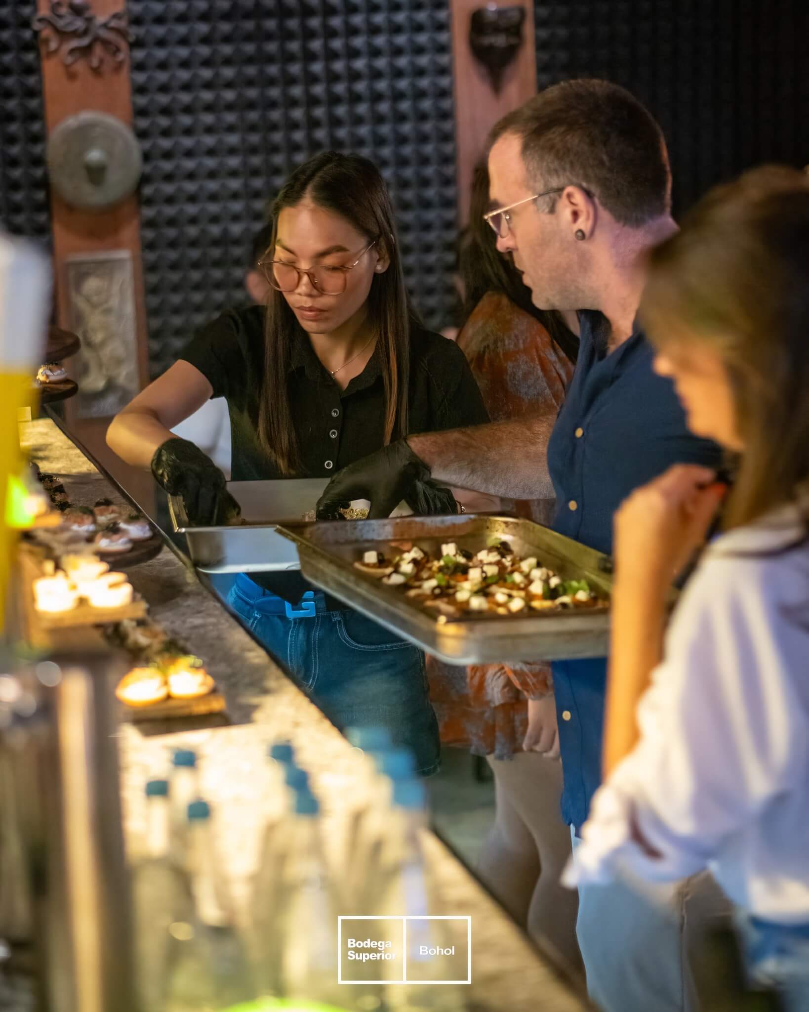 Tasting at Bodega Superior — chef plating canapés on the bar